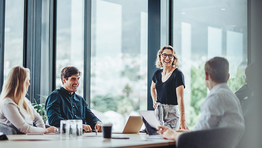 Group of people smiling in conference room.